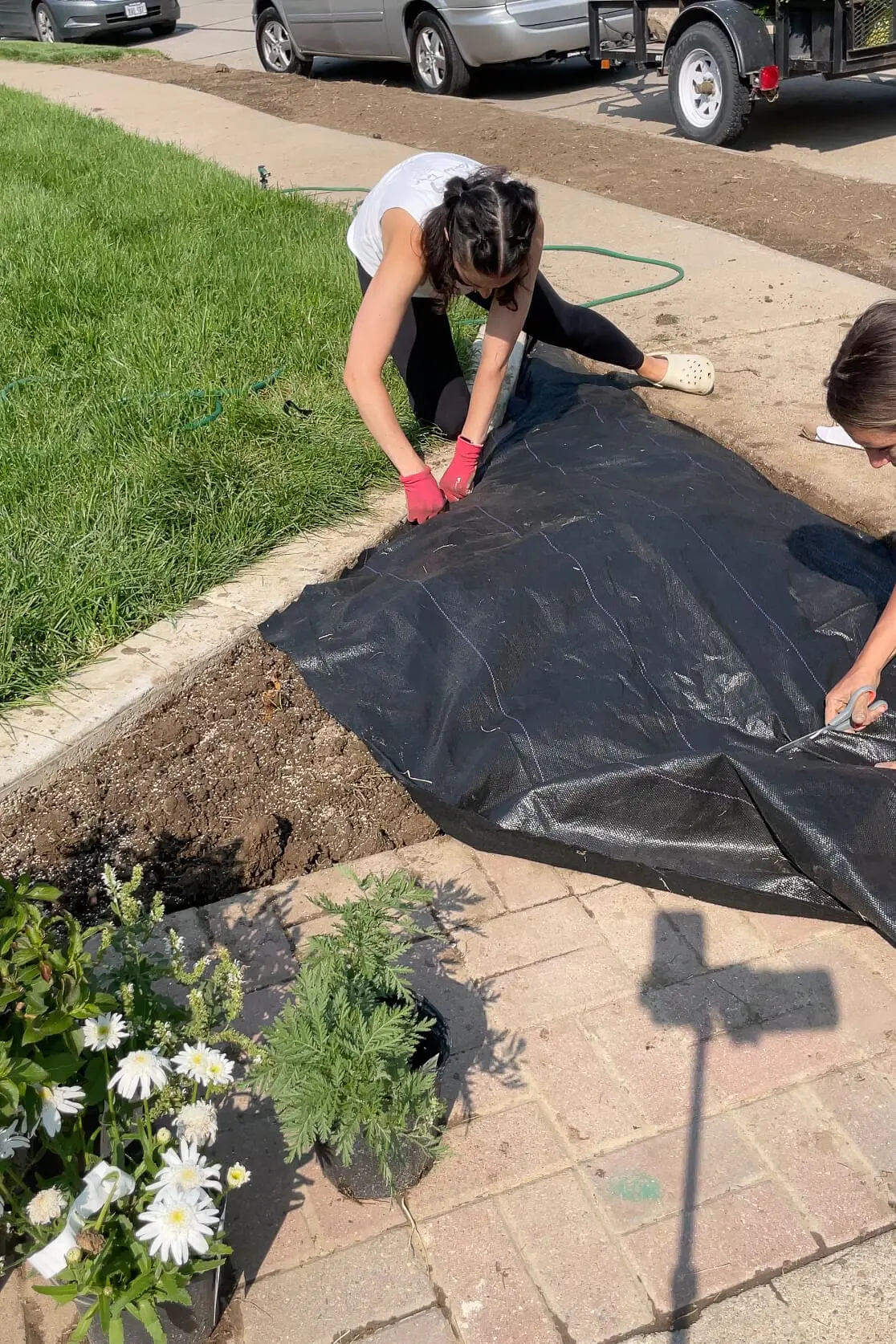 Adding weed barrier to a landscaping bed. 